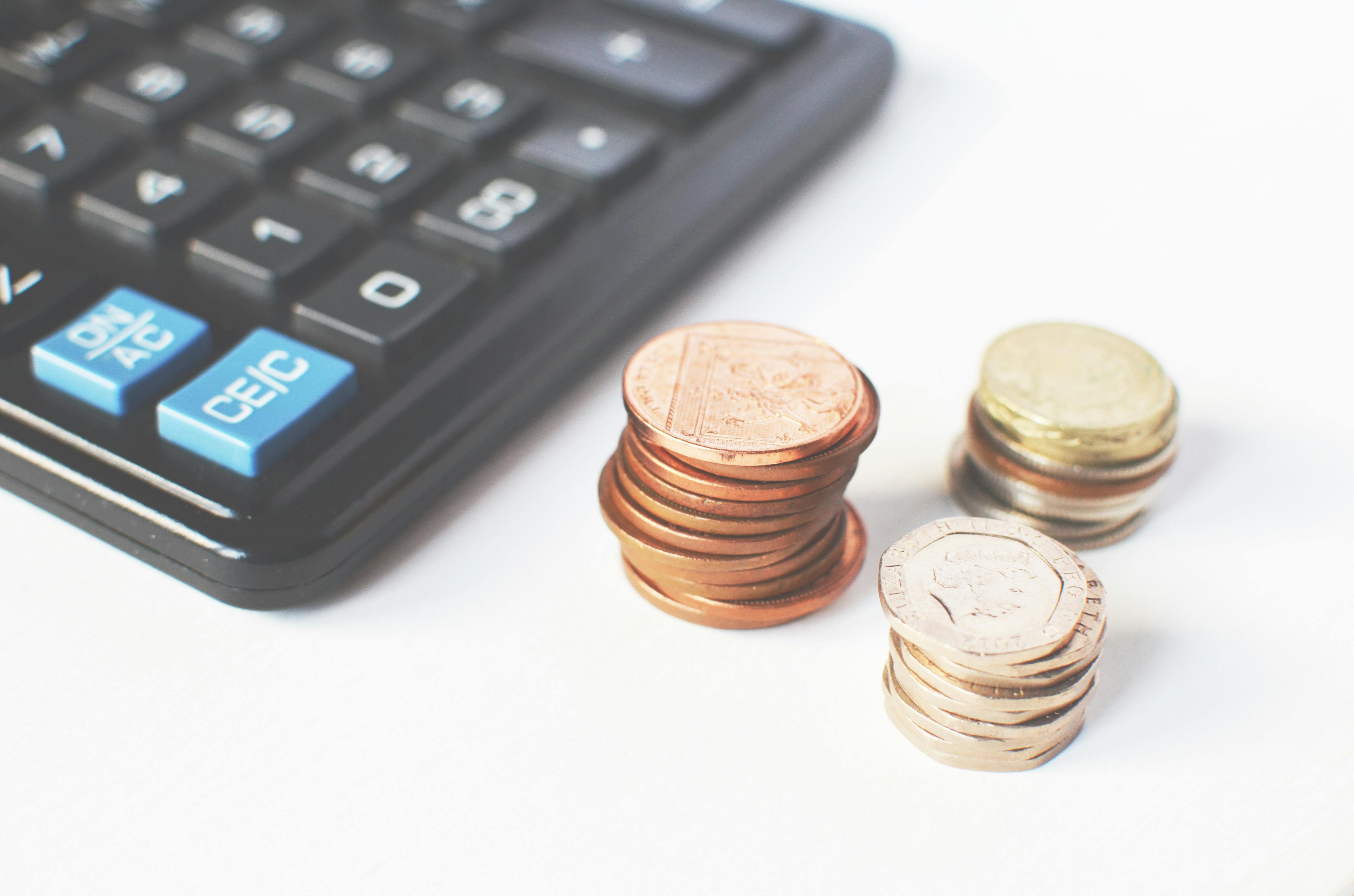 Calculator and stacks of coins representing goal-setting for investing in South Africa